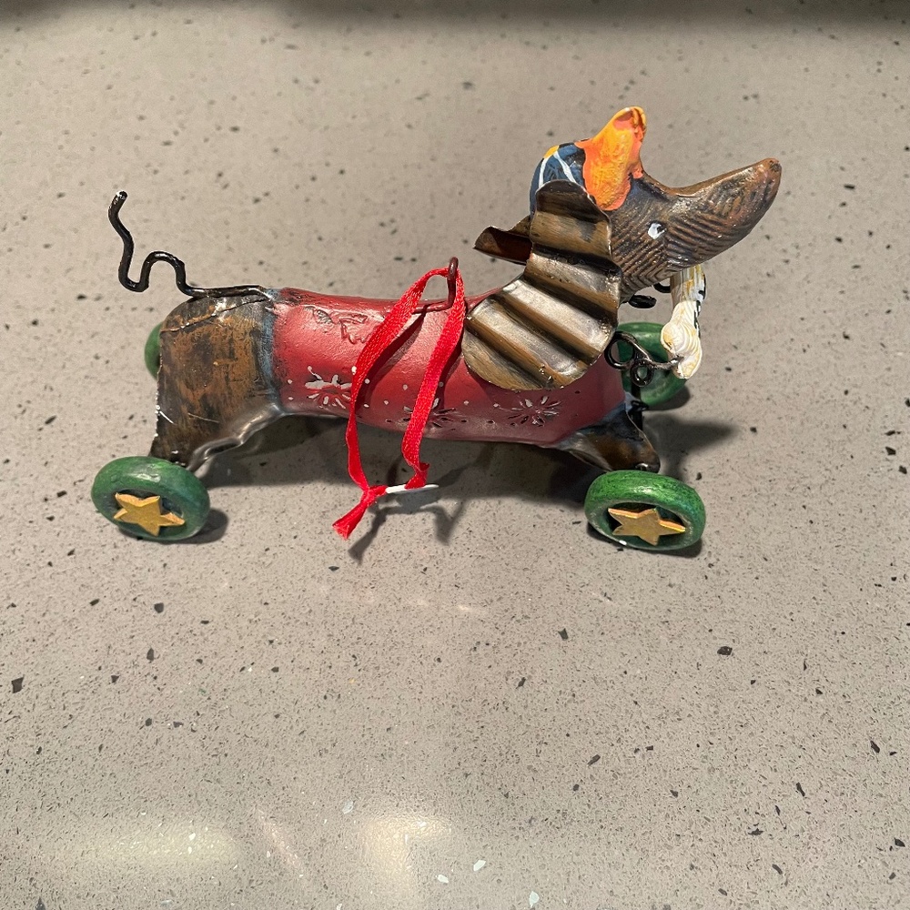 Vintage metal dog ornament on wheels